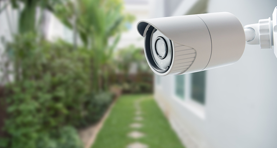 Outdoor security camera overlooking side yard of house